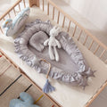Gray crib bumper with star decorations in a crib with toys